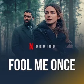 Two individuals stand in a forest, exuding tension. The woman, in a black coat, looks pensively ahead; a man behind her watches intently. Text reads "Netflix series, Fool Me Once."