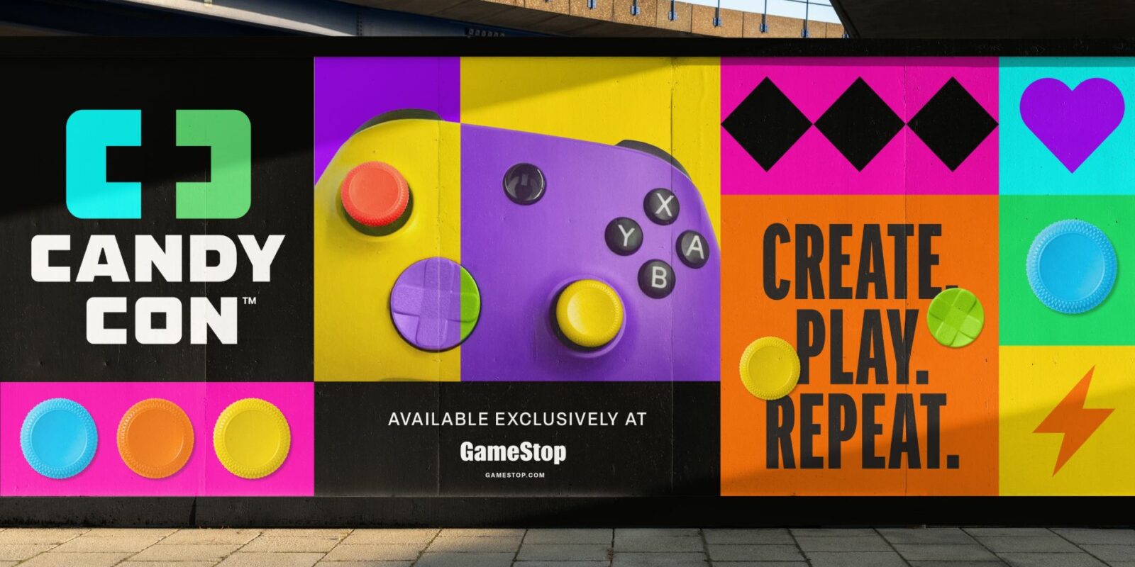 Bright billboard for "Candy Con" featuring vibrant game controller design and colorful symbols. Text reads "Create. Play. Repeat." Available at GameStop.